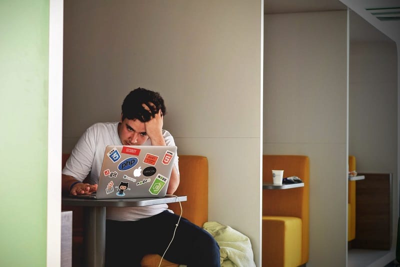 an anxious man is working on his laptop