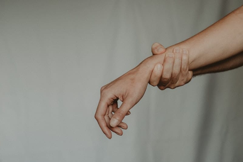 one person holds another person by the wrist