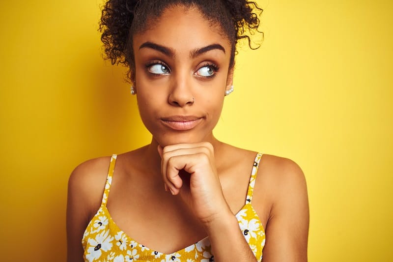 young woman with curly hair thinking about work-life balance tips