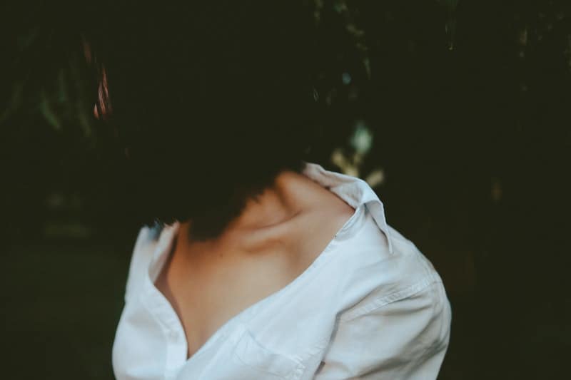 sad young woman with a bob haircut and wearing a white shirt