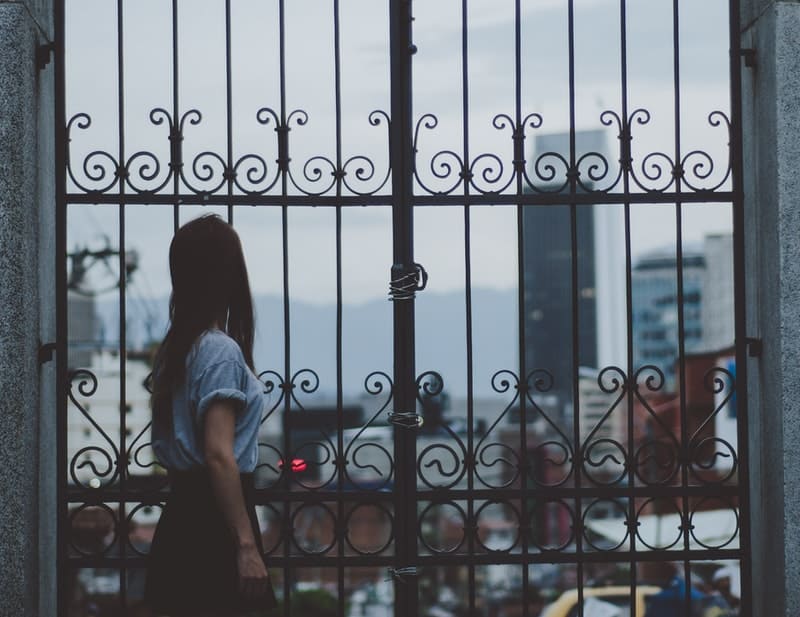 pensive young woman looking at the city in the distance