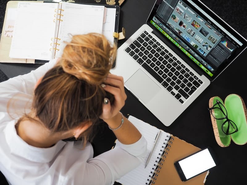stressed out woman overthinking while working on her laptop