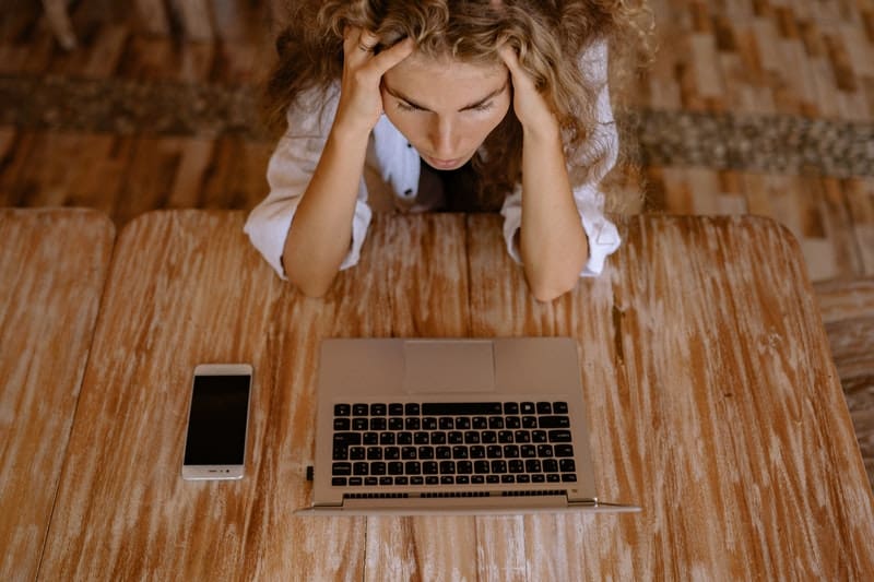 stressed out woman thinks about quitting her job while working on her laptop