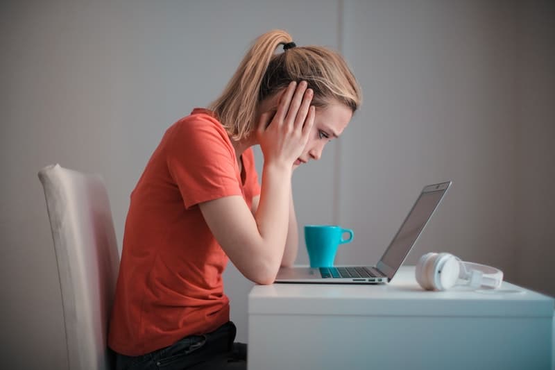 young woman on her laptop thinking about quitting her job