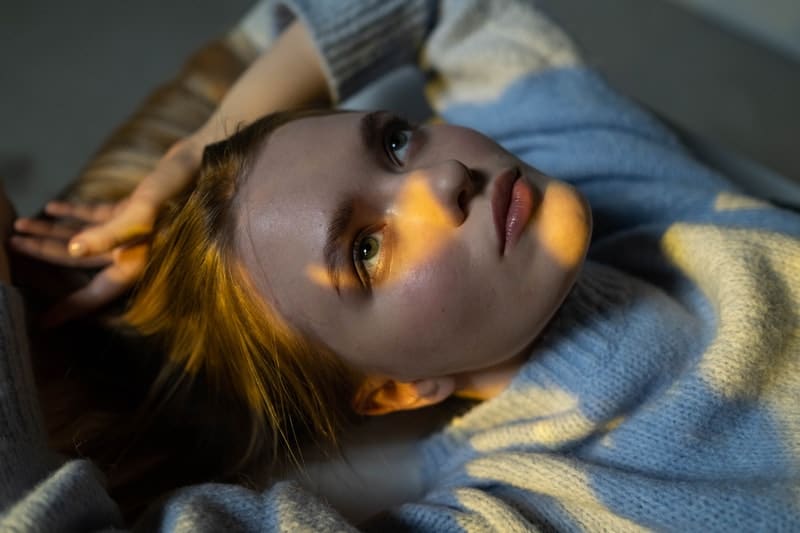 young woman laying in bed trying to let go of resentment