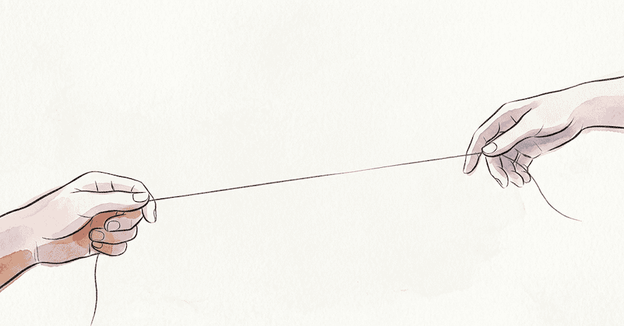 Two hands connected by a single thin thread, one hand steady and close, the other drifting further away toward the edge of the frame.