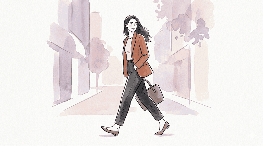 woman walking forward at her own pace, glancing back over one shoulder with a slight, confident half-smile. The glance is brief, not lingering. Her body is still oriented forward, feet still moving.