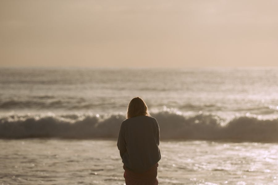 woman walks alone on the beach